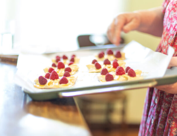 Unbaked raspberry tarts on a baking tray.